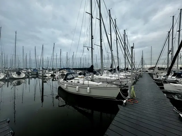 Steg mit Segelbooten unter grauem Himmel