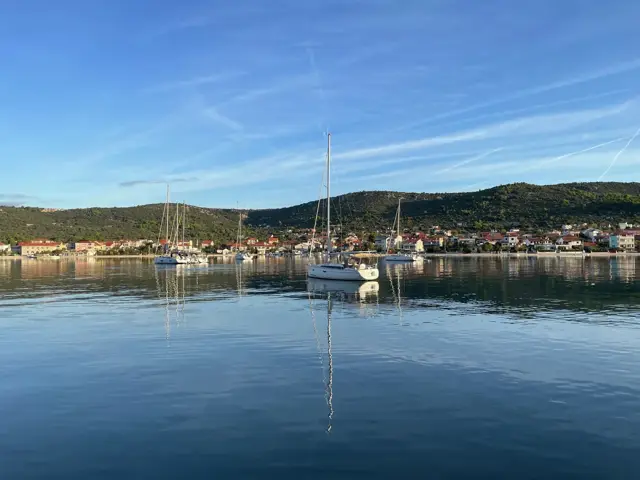 Ankernde Segelboote vor einem Küstenort