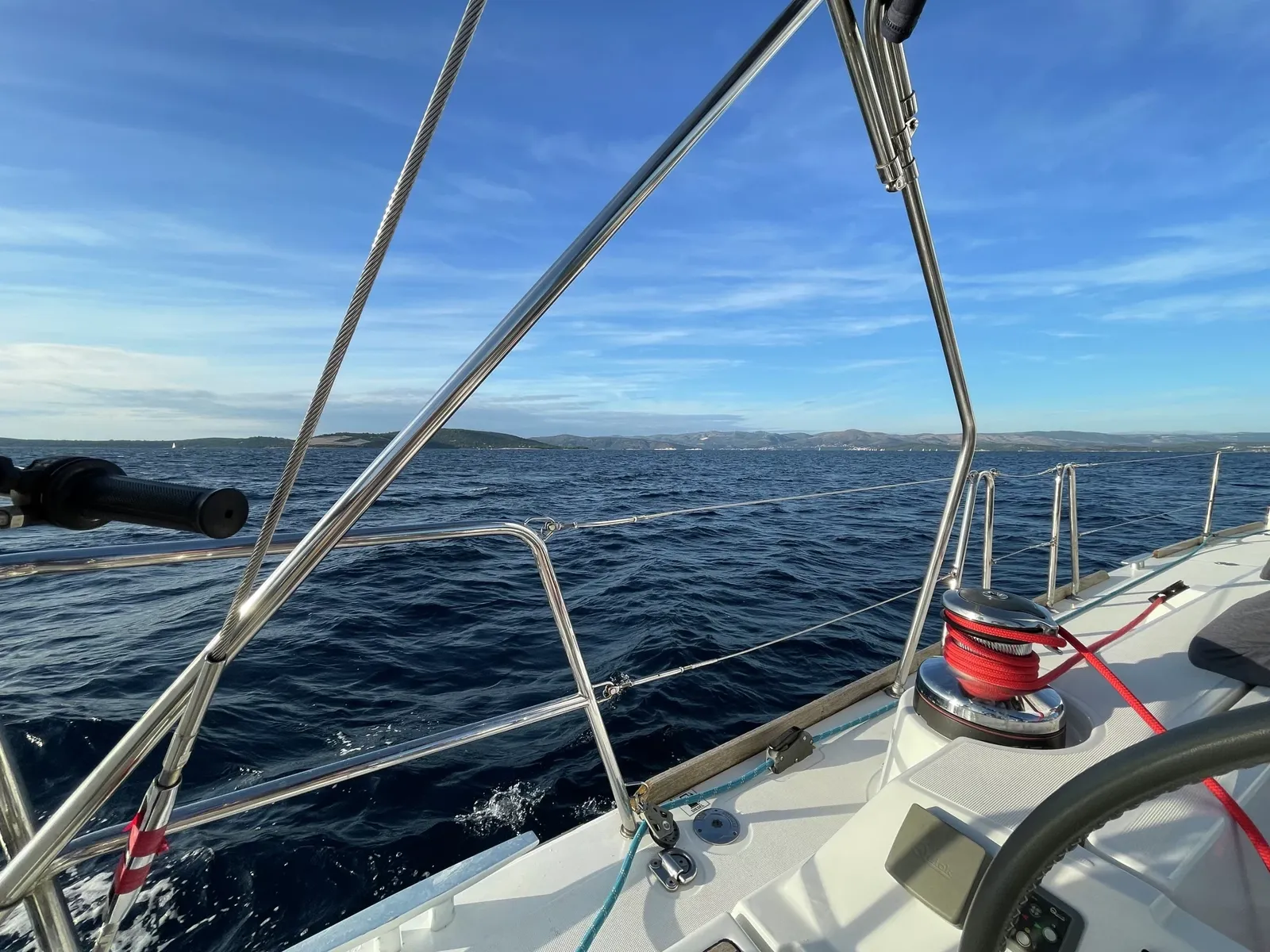 Unter Segeln: Blick vom Cockpit über Winsch und Reling aufs Meer
