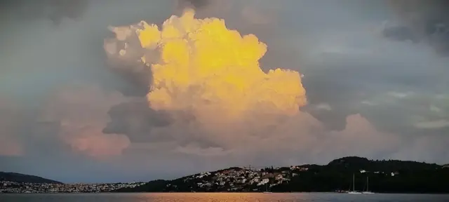 Leuchtende Gewitterwolke über der Küste in der Abenddämmerung