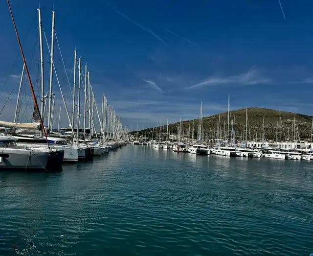 Marina mit langen Stegreihen vor einem Hügel