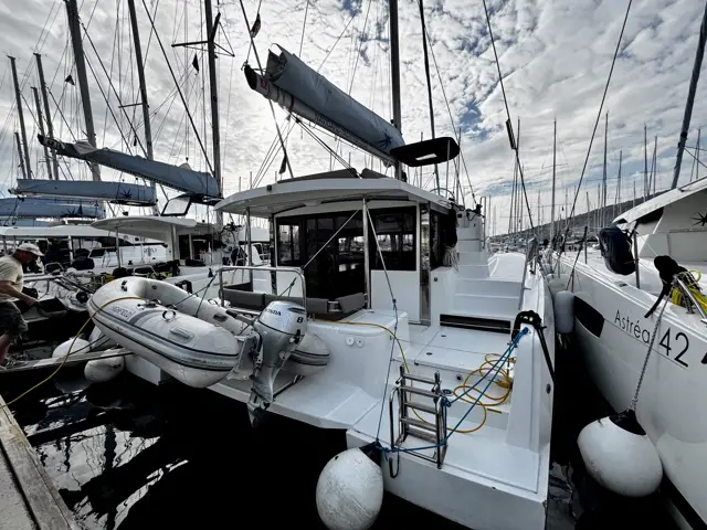 Katamaran mit Beiboot am Heck, Fender ausgebracht