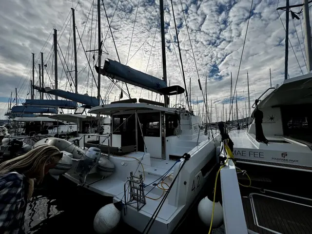 Crewmitglied an Deck beim Klarmachen des Katamarans