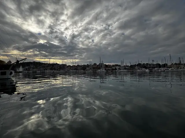 Wolkenhimmel spiegelt sich im Hafenwasser