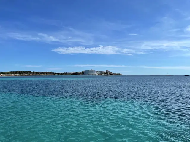 Türkises Wasser vor einer flachen Küste mit Gebäuden