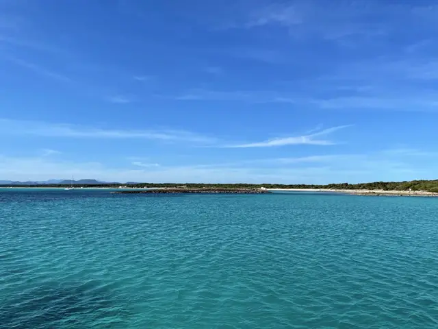 Türkisfarbene Bucht vor einem langen Strand