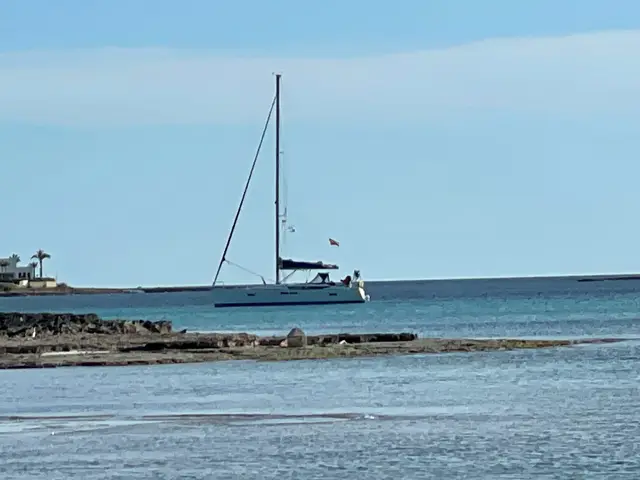 Segelyacht vor Anker hinter einer Felsküste
