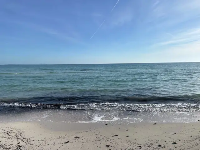 Sandstrand mit kleinen Wellen